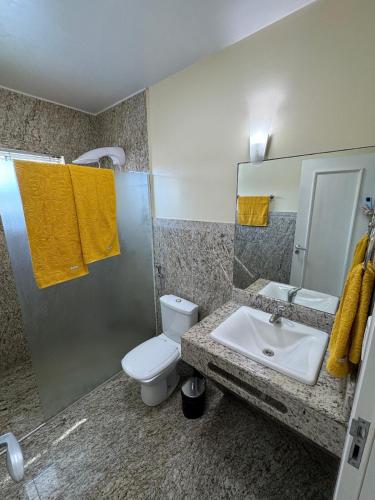 a bathroom with a toilet and a sink at Hospedaria Sewald in Treze Tílias