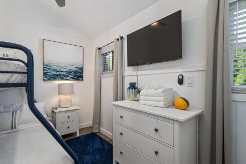 a bedroom with a dresser with a flat screen tv at Dog Friendly Hot Tub Walk to Beach in Southern Shores