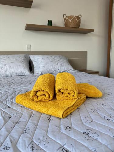 a bed with two yellow towels on it at Hospedaria Sewald in Treze Tílias