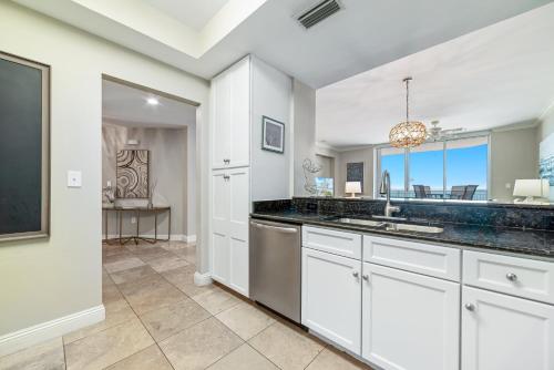 una cucina con mobili bianchi e un lavandino di Indigo Unit 702E a Pensacola