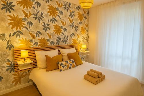 une chambre avec un grand lit avec du papier peint jaune et vert dans l'établissement T2 lumineux cosy avec terrasse - parking privée & métro Borderouge 5 min - proche centre ville, à Toulouse