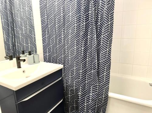 une salle de bain avec un lavabo et un rideau de douche dans l'établissement T2 lumineux cosy avec terrasse - parking privée & métro Borderouge 5 min - proche centre ville, à Toulouse