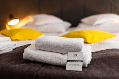 a pile of towels sitting on top of a bed at Hotel Nafta Krosno in Krosno