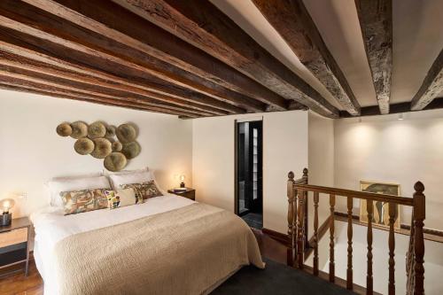 une chambre avec un lit et un plafond en bois dans l'établissement Un 1-Ch/1-SdB Confortable- Place des Vosges, à Paris
