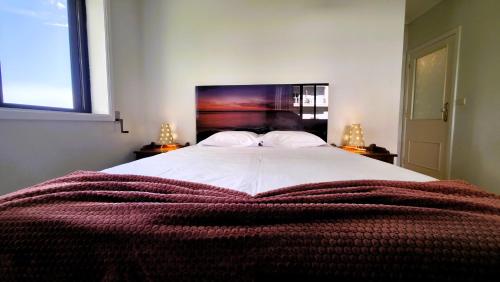a bedroom with a large bed with a red blanket at Amorosa Beach Apartment Family in Viana do Castelo