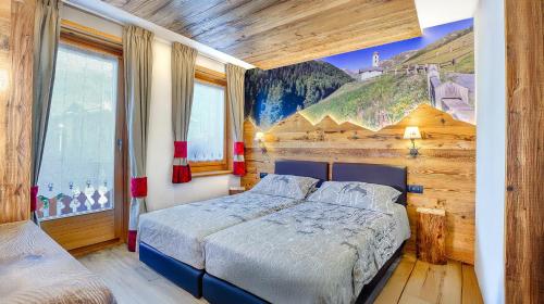 a bedroom with a bed and a painting on the wall at Baita Lorella in Livigno
