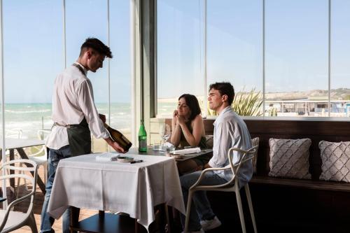 a group of three people sitting at a table in a restaurant at Luna Minoica Suites and Apartments in Montallegro
