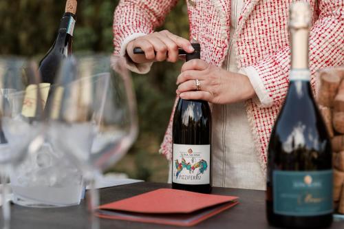 a woman holding a bottle of wine on a table at Luna Minoica Suites and Apartments in Montallegro