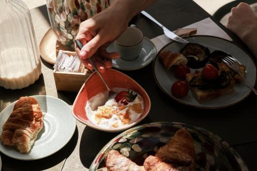 a person eating food on a table with plates of food at Luna Minoica Suites and Apartments in Montallegro