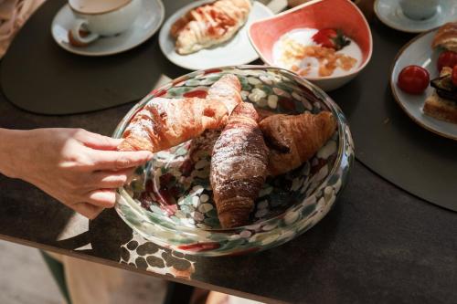 a person holding a bowl of pastries on a table at Luna Minoica Suites and Apartments in Montallegro