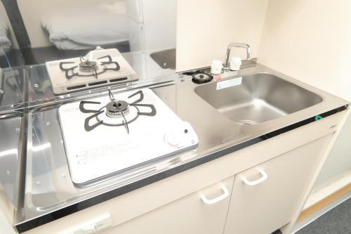 a kitchen with a stove and a sink at SOKOResort Hayama in Yokosuka