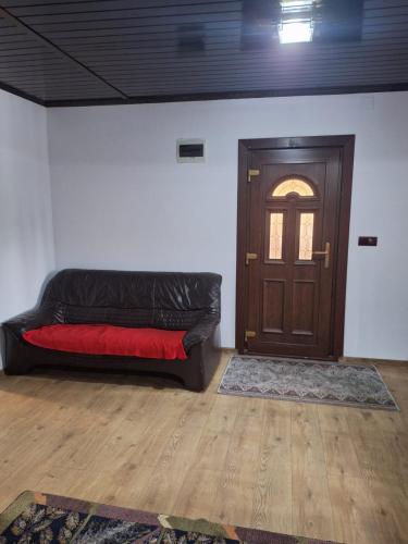a black couch in a room with a door at Cabana Suzanne Băile Figa-cu aer conditionat in Agrişu de Sus