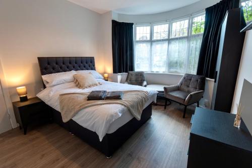 a bedroom with a large bed and a chair at Modern Double Room with Broadband, Private TV and seating area - Room 1 in Solihull