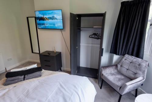 a bedroom with a bed and a chair and a mirror at Modern Double Room with Broadband, Private TV and seating area - Room 1 in Solihull