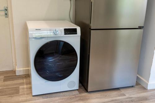 a white washing machine next to a refrigerator at Modern Double Room with Broadband, Private TV and seating area - Room 1 in Solihull