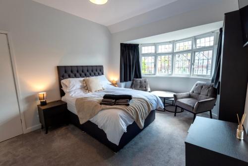 a bedroom with a large bed and a chair at Modern Double Room with Broadband, Private TV and seating area - Room 1 in Solihull