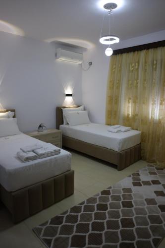 a hotel room with two beds and a window at Villa Nano in Berat