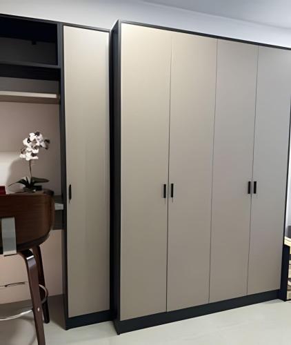 a pair of white cabinets in a room with a desk at Studio Concept Avenida das Esmeraldas in Marília
