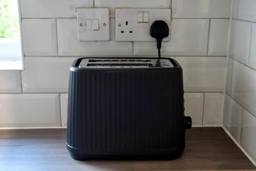 a black suitcase sitting on the floor in a room at Modern Double Room with Broadband, Private TV and seating area - Room 1 in Solihull