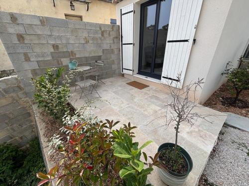 un patio avec une table, des chaises et des plantes dans l'établissement Studio cosy avec exterieur, à La Celle-sous-Gouzon