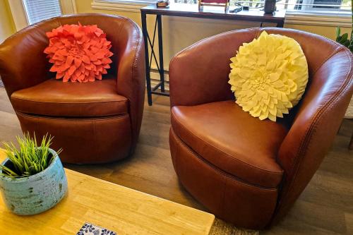 Dos sillas con flores junto a una mesa. en Neskowin Nautical Nook, en Neskowin