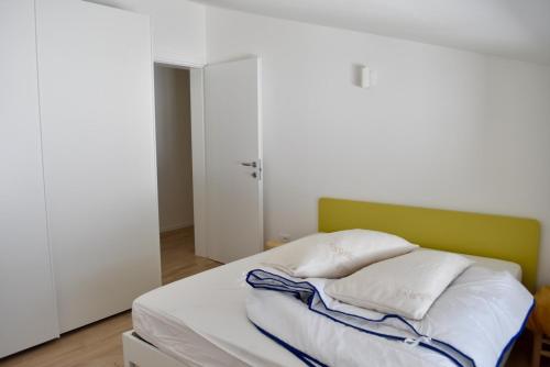a bed with white sheets and pillows in a room at salvia in Arta Terme
