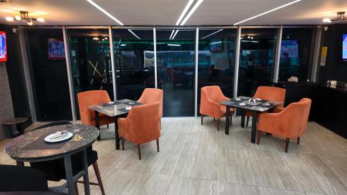a restaurant with two tables and orange chairs at Hotel Vip La Guaira in Macuto