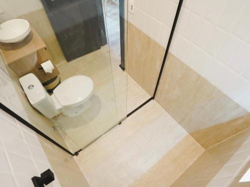 a bathroom with a toilet and a glass wall at Apê Santos Praia do Gonzaga in Santos
