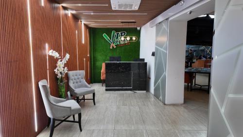 a hallway with two chairs and a green wall at Hotel Vip La Guaira in Macuto