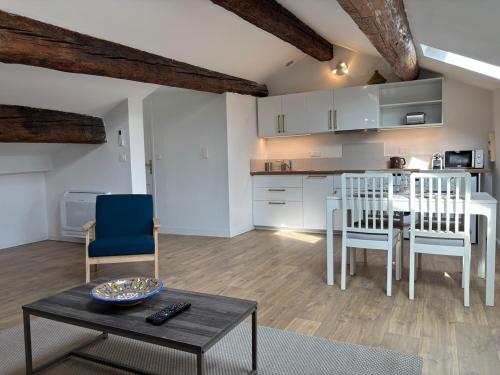 un salon avec une table et des chaises et une cuisine dans l'établissement Air-conditioned apartment, à Avignon