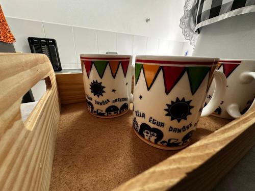 two coffee mugs sitting on top of a counter at Ap da Thay - Os Três Pandeiros in Campina Grande