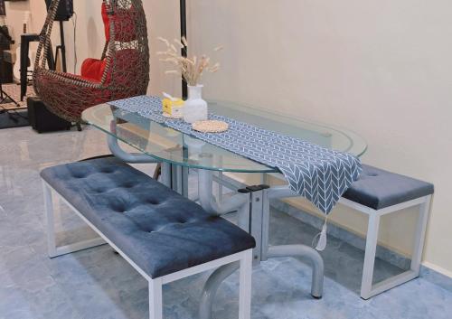 a glass table with two stools and a glass bench at 2F-Homestay at Pontian, MusIim-friendly accommodation in Kampong Atap