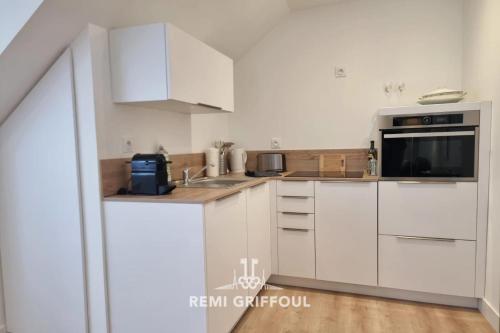une cuisine blanche avec un évier et un micro-ondes dans l'établissement Hypolite 5 Elegant Apartment 80 meters from Honfleur Port 2 guests, à Honfleur