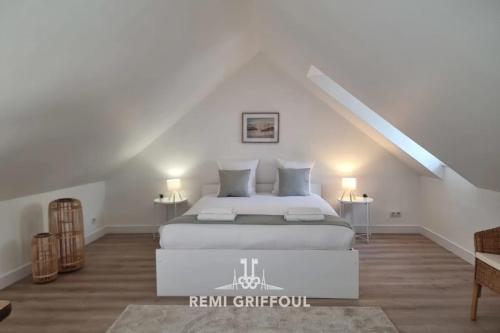 une chambre avec un lit blanc dans un grenier dans l'établissement Hypolite 5 Elegant Apartment 80 meters from Honfleur Port 2 guests, à Honfleur