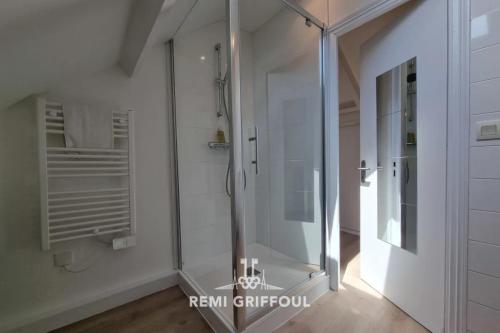 une cabine de douche en verre dans une salle de bains aux murs blancs dans l'établissement Hypolite 5 Elegant Apartment 80 meters from Honfleur Port 2 guests, à Honfleur