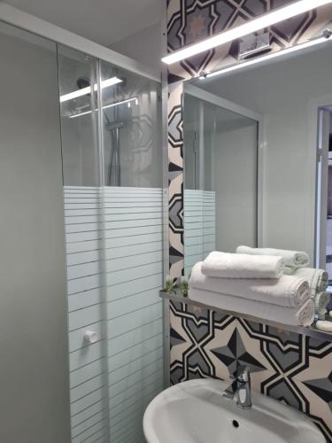 une salle de bain avec un lavabo et un miroir dans l'établissement Hôtel Arcades, à Lourdes