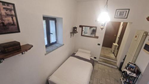 a small room with a bed and a mirror at La Casina in Maccagno con Pino e Veddasca