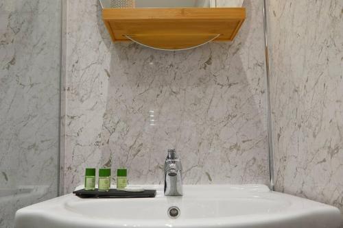 a bathroom sink with a faucet and a mirror at Seascape - Fantastic Location with Sea Views! in Scarborough