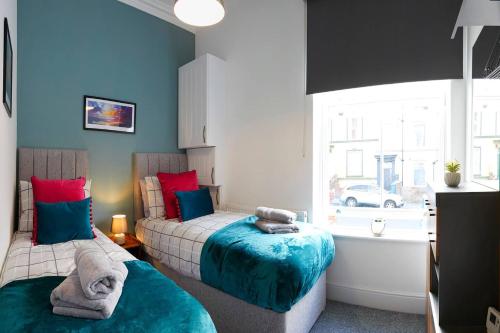 a bedroom with two beds and a window at Seascape - Fantastic Location with Sea Views! in Scarborough