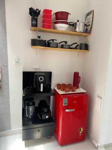 a small kitchen with a red refrigerator and shelves at Lofts Paraíso de Alcobaça in Alcobaça