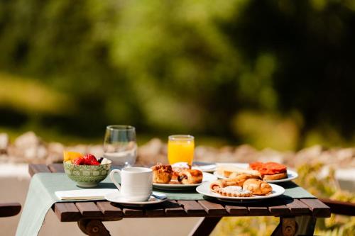 a table topped with plates of food and orange juice at Hotel Rural Binigaus Vell in Es Migjorn Gran