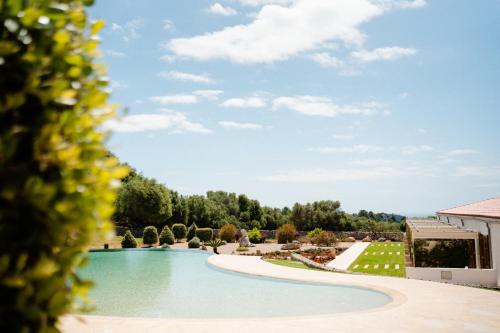 a view of a swimming pool at a resort at Hotel Rural Binigaus Vell in Es Migjorn Gran