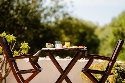 a table with a tray of food and two chairs at Hotel Rural Binigaus Vell in Es Migjorn Gran