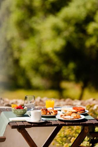 a table with plates of food and a glass of orange juice at Hotel Rural Binigaus Vell in Es Migjorn Gran