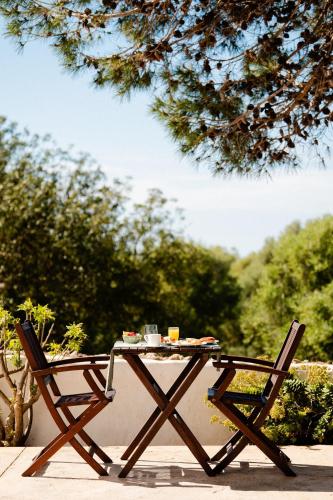 a picnic table and two chairs on a patio at Hotel Rural Binigaus Vell in Es Migjorn Gran