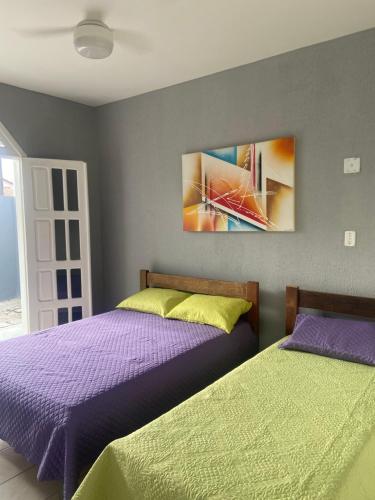 a bedroom with two beds and a painting on the wall at Lofts Paraíso de Alcobaça in Alcobaça
