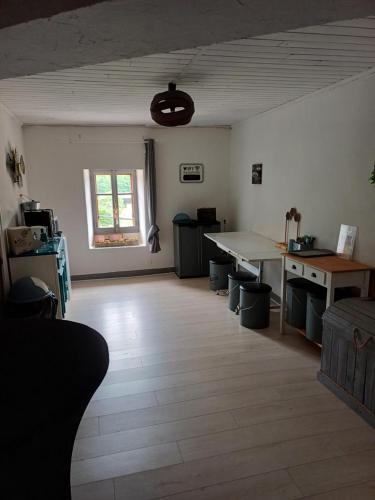 un salon avec une table et un bureau dans l'établissement Auberge des Platanes, à Villevocance