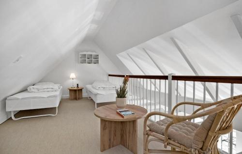 a attic room with two beds and a chair at Apartment Klint Strandvej Nykøbing Sj Vi in Højby