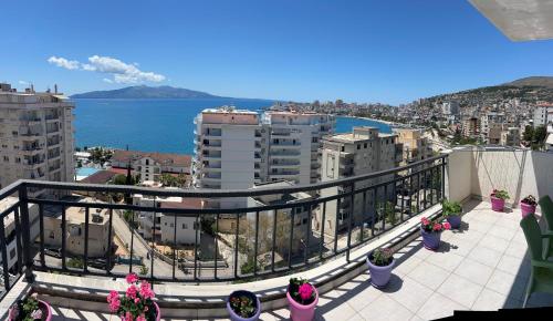a balcony with a view of the ocean and buildings at Azalea Apartments in Sarandë