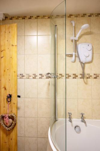 a bathroom with a shower and a bath tub at The Barn, rustic country cottage dog friendly in Whitby